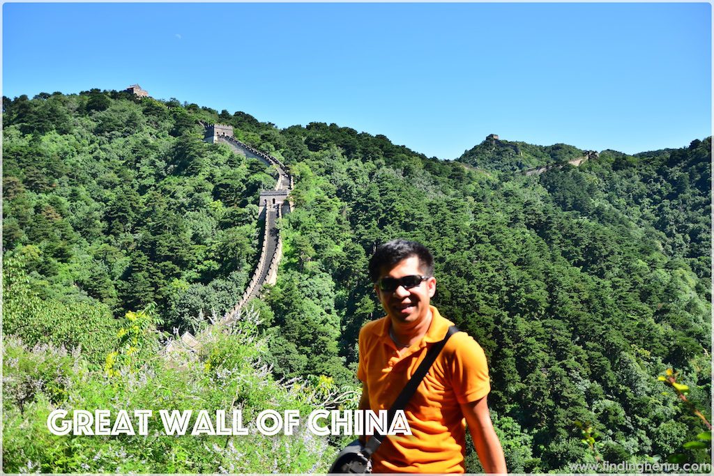 i am posing at one side where the Great Wall on the mountains are visible